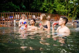 Family drinks juice in pool at Ecotermales Hot Springs